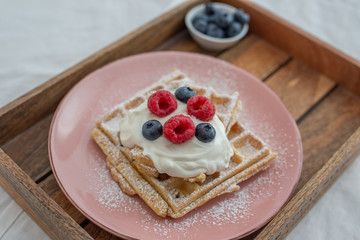 Fresh sugar waffles with castor sugar and berries