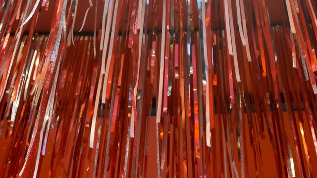 Red ribbon hanging on the wall with decorative lights in the background
