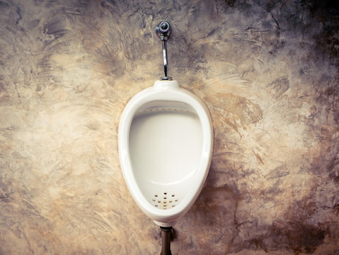 Closeup of white urinals in men's bathroom, design of white ceramic urinals for men in toilet room