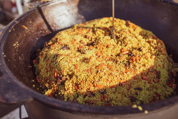 Rice pilaf in a cauldron at the stake