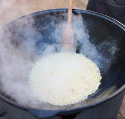 Onions are fried in a cauldron at the stake