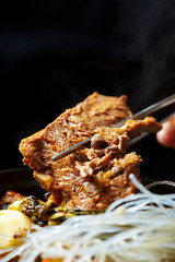Korean pork rib dish, eating with chopsticks 