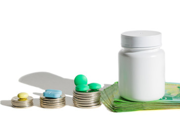 Stacks of coins with the pills. The concept of expensive treatment. The high price of medicines. Multi-colored pills. Isolate with copy space.