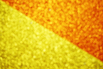 Abstract defocused shiny sparkle yellow and orange glitter bokeh background