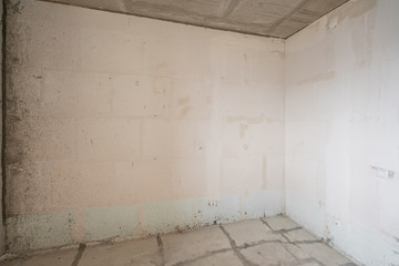 Empty interior for design, gray concrete wall. Empty room. Space for text and picture. Concrete walls, slabs, interior of a new residential building. Partitions in a new apartment.