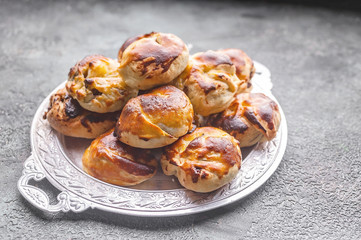Close up sweet homemade buns with salted caramel and nuts on a plate.