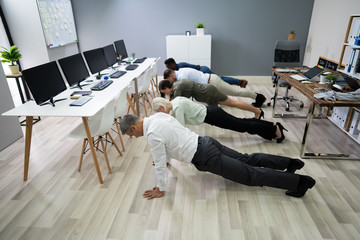 Group Of People Doing Pushups At Work