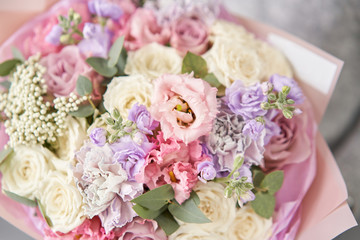 European floral shop. Beautiful bouquet of mixed flowers in womans hands. the work of the florist at a flower shop. Delivery fresh cut flower.