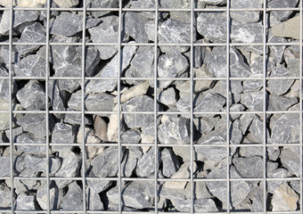 texture of wall made of grey stone through the bars