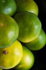 Green tangerines. Fancy fruits. Background