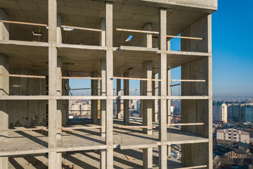 Obraz premium Aerial view of concrete frame of tall apartment building under construction in a city.