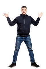 Smiling young man in jeans and a hoody is jumping. Full height. Isolated over white background. Vertical.
