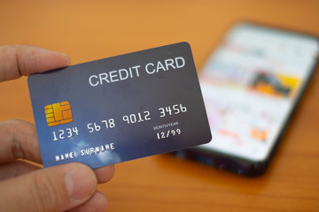 Hands holding plastic credit card and using Mobile Phone for online shopping. Online shopping concept