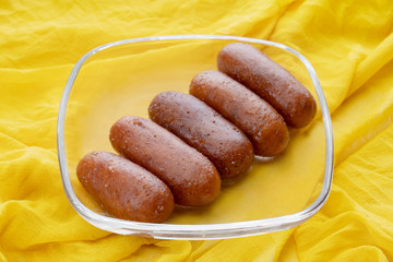 Langchas kept in a glass bowl on a yellow cloth. 	
