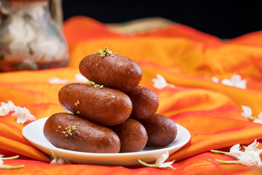 Langchas kept in a white plate on an orange cloth. 	