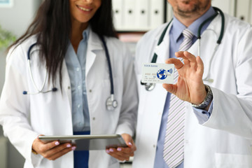 Two doctors showing plastic card in camera close-up