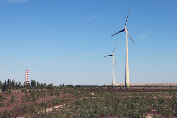 Wind generator on the field.  Power station on the background. Concept photo. 