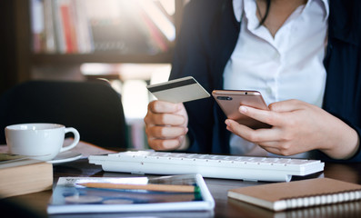 Fototapeta premium Close up of hand. young female using credit card payment or shopping online by mobile phone