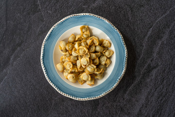 Homemade Russian Pelmeni Fried Plain Dumplings with Meat, Yogurt, Tomato Sauce and Spices.