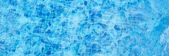 Blue swimming pool water. Panoramic background with reflections