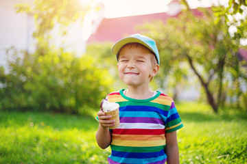 Happy child eating ice cream outdoors in summer