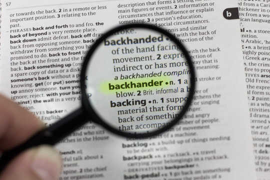 The word or phrase backhander in a dictionary.