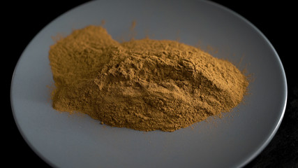 Subject shooting. In the frame is a plate of cinnamon powder. Spice, an ingredient for cooking.