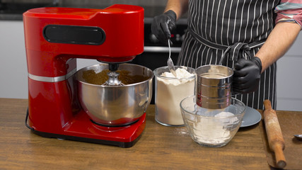 The process of the kitchen mixer. Mixing products to get the dough. Cooking cupcakes or gingerbread.