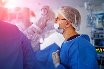Medical team helping patient. Modern equipment in operating room.