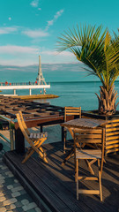 View of the coastline. Massandra beach, Yalta, Crimea. Wooden tables and chairs on the waterfront by the sea