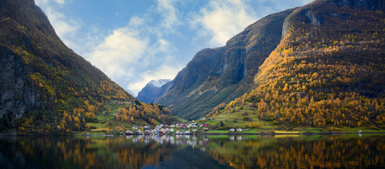 The village of Undredal is a small village on the fjord. Aurlandsfjord West coast of Norway, High mountains and villages reflect in the water during autumn season.