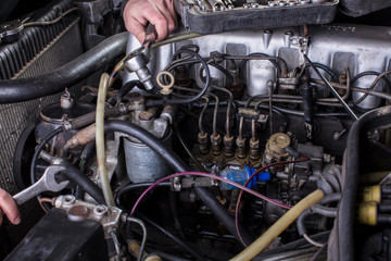 Car engine repair. Diesel engine services. Hands with a mechanic with a wrench repair Mercedes parts.