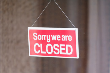 Sorry we are closed sign in shop window door