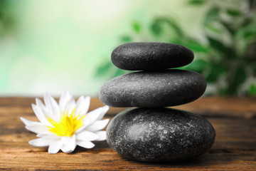 Obraz na płótnie Canvas Zen lifestyle. Beautiful lotus flower and stones on wooden table