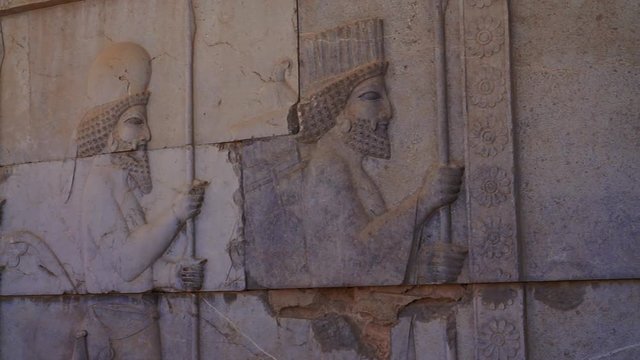 Panning right | Persepolis Lion and Bull Relief | Ancient ruins of Persepolis near Shiraz, Southern Iran. This walls's relief shows many things in the past of Persian empire | Silk Road Iran