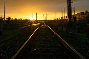 Fototapeta na wymiar Railroad track vanishing in the distance at sunrise