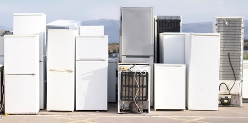 Old fridge freezer refrigerator refrigerant gas at refuse dump skip recycle stacked pile plant help...