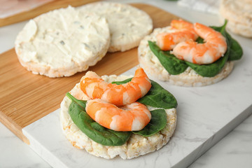 Puffed rice cakes with shrimps and basil on board, closeup