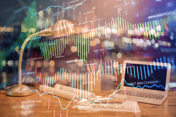 Double exposure of chart and financial info and work space with computer background. Concept of...
