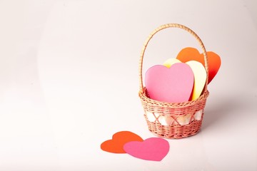 Fototapeta na wymiar Paper colored hearts in basket on a white background. Hollidays. Valentine's Day