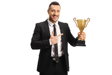 Businessman smiling and holding a golden trophy cup