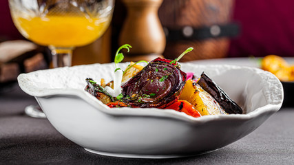 Modern Ukrainian cuisine in the European style. Grilled vegetables, tomato, red onion, eggplant, carrots and zucchini. Edible flowers as a decor. background image, copy space text