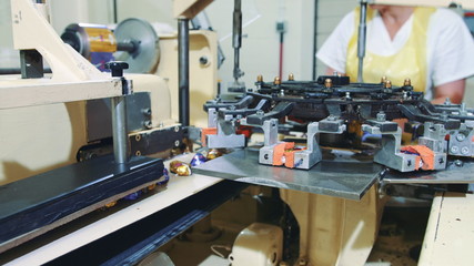Candy factory. Industrial machine wrapping candies. Modern industrial machine wrapping tasty sweets and putting them on conveyor on confectionery factory.