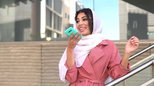 Young Muslim woman wearing hijab using smart phone