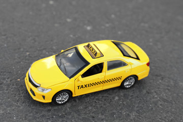 Yellow taxi car model on city street
