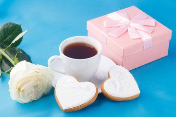 Heart-shaped cookies and a rose on the blue background, a gift for Valentine's Day