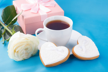 Fototapeta na wymiar Heart-shaped cookies and a rose on the blue background, a gift for Valentine's Day