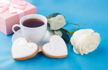 Heart-shaped cookies and a rose on the blue background, a gift for Valentine's Day