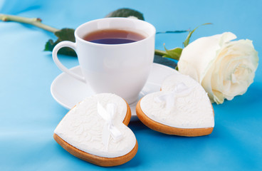 Heart-shaped cookies and a rose on the blue background, a gift for Valentine's Day