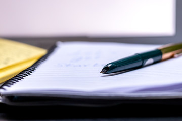 Blogger concept. There is a pc laptop with notebook and pen at a table in a cafe. selective focus